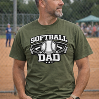 Man wearing a green 'Softball Dad' t-shirt on a sports field.